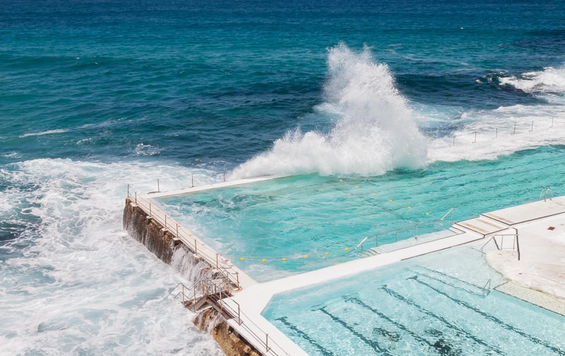 Welle schlägt über die Wand des Pools