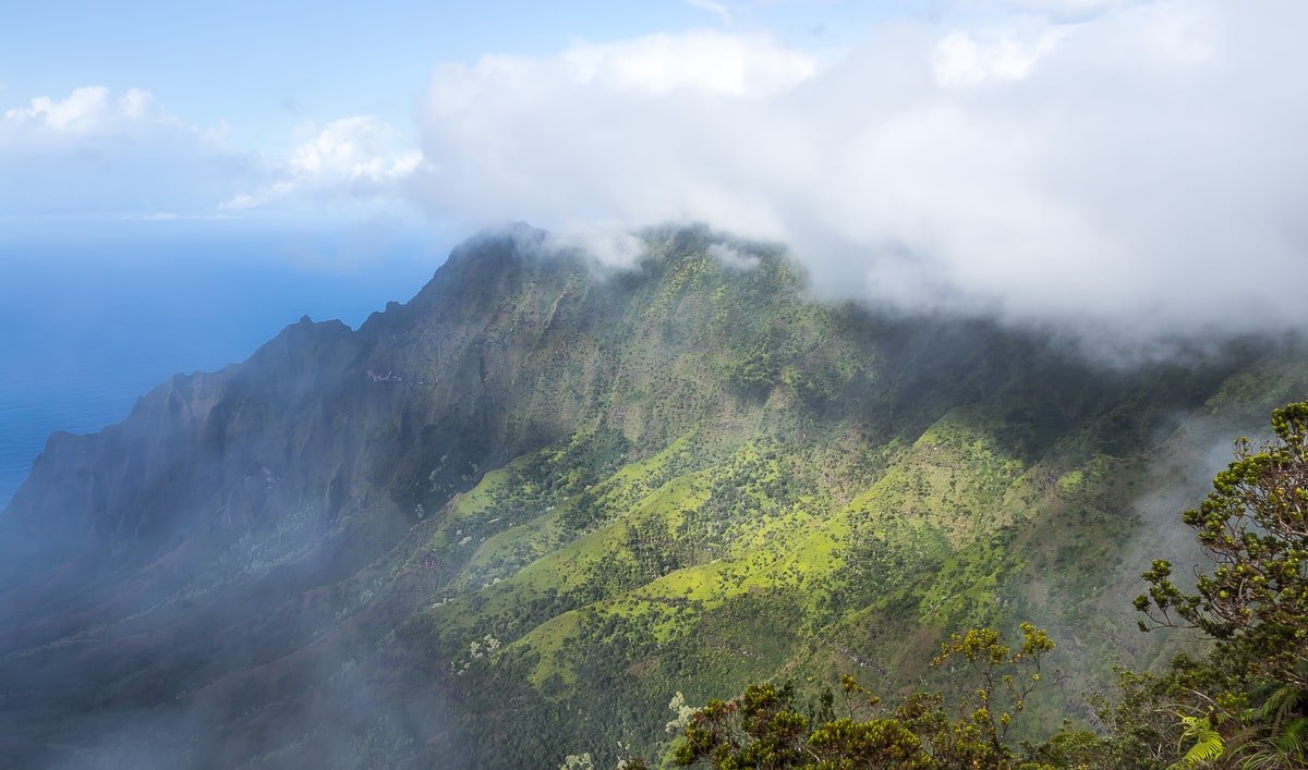 Wolken ziehen die hawaiianischen Berge hinauf